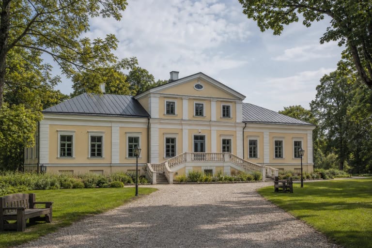 Restauruoti gelsvi Maišiagalos Houvalto dvaro rūmai su trikampiu frontonu ir baltais laiptais
