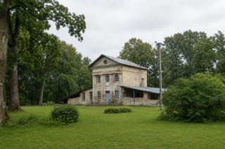 Mantagailiškis Manor's weathered masonry house with a low side wing and mature park trees