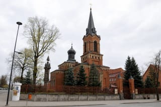 Red-brick St Vincent de Paul Church in Marijampolė with a tall tower and smaller turrets