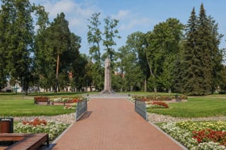 Краснокирпичная дорожка и мостик через Евонис в парке Витовта Великого, рядом с конным памятником среди взрослых деревьев