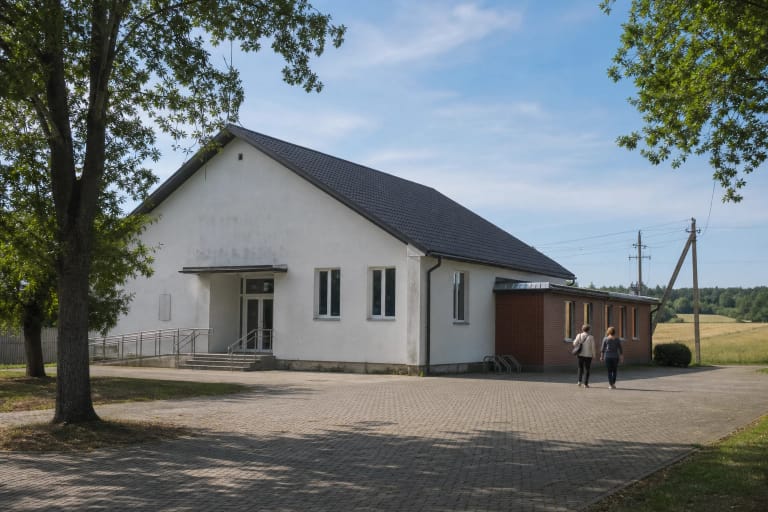 Urvikių kultūros centro kiemas su medine liaudies skulptūra ir medžiais