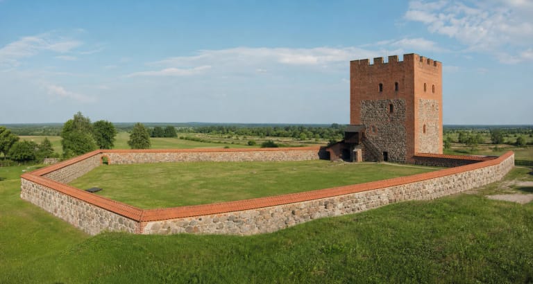 Medininkų pilies raudonų plytų donžonas ir lauko akmenų gynybinės sienos su žaliu kiemu