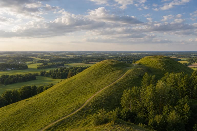 Medvėgalio piliakalnio žali kalvų šlaitai ir Žemaičių aukštumos panorama