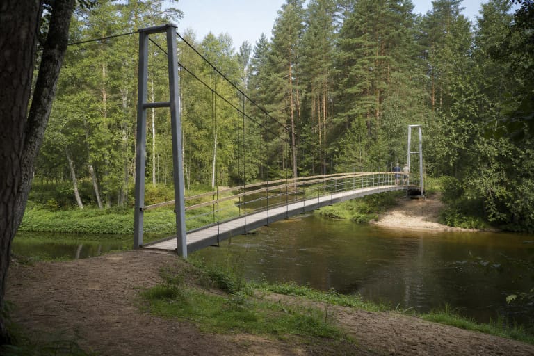 Mikierių kabantis tiltas su mediniu paklotu ir plieniniais lynais virš miškingos Šventosios