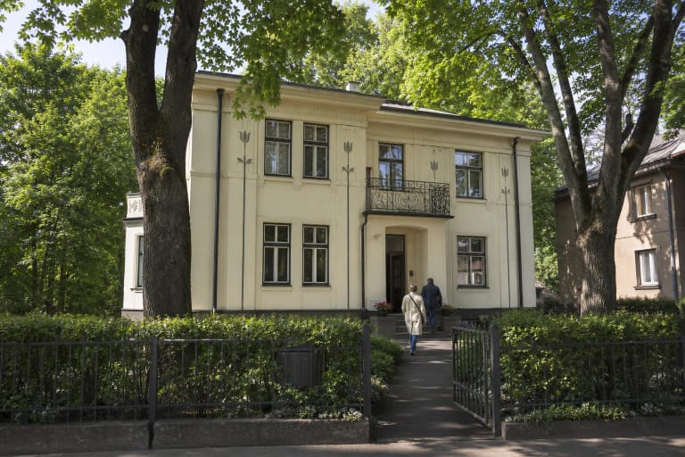 Šviesus dviejų aukštų Miko ir Kipro Petrauskų namas su balkonais ir tulpių dekoru Žaliakalnyje