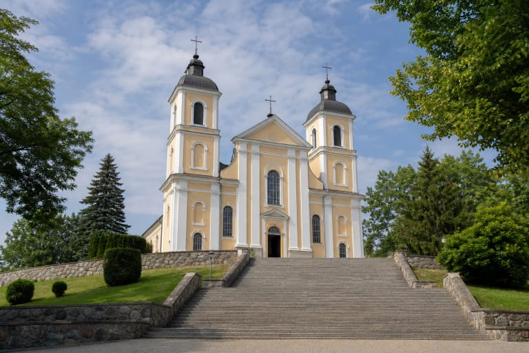 Šviesiai gelsva Molėtų Šv. apaštalų Petro ir Povilo bažnyčia su dviem atkurtais bokštais