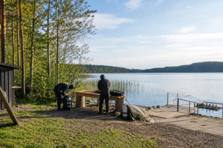 Du narai ruošia įrangą ramioje miškingoje Platelių ežero pakrantėje