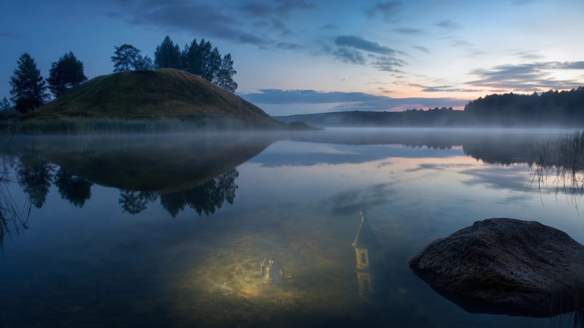 A hillfort rises by Lake Obelija, as if the bells of a hidden church could be heard through the mist