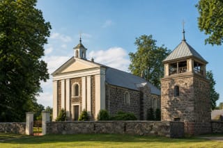 Pabaiskas Church of the Holy Trinity in stonework with white pilasters and a detached belfry