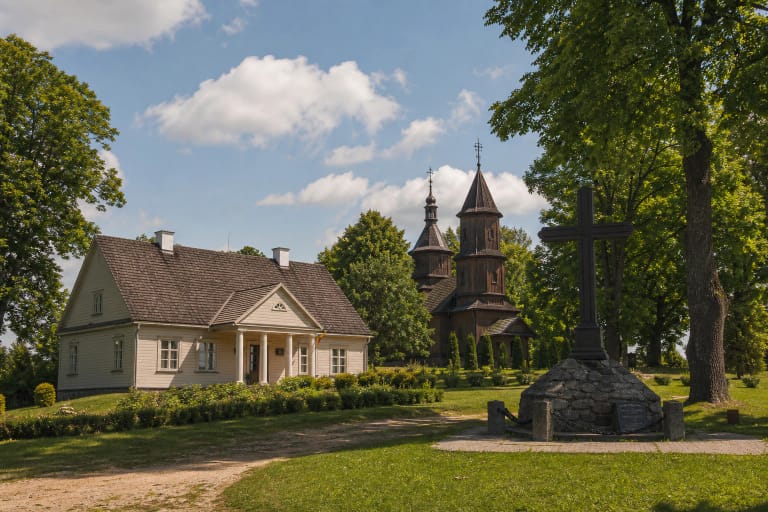 Paberžės 1863 metų sukilimo muziejaus dvaro pastatas ir medinė bažnyčia ramioje kaimo aplinkoje