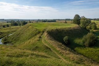 Grassy ramparts and broad platform of Pajevonys Hillfort in the fields of Suvalkija