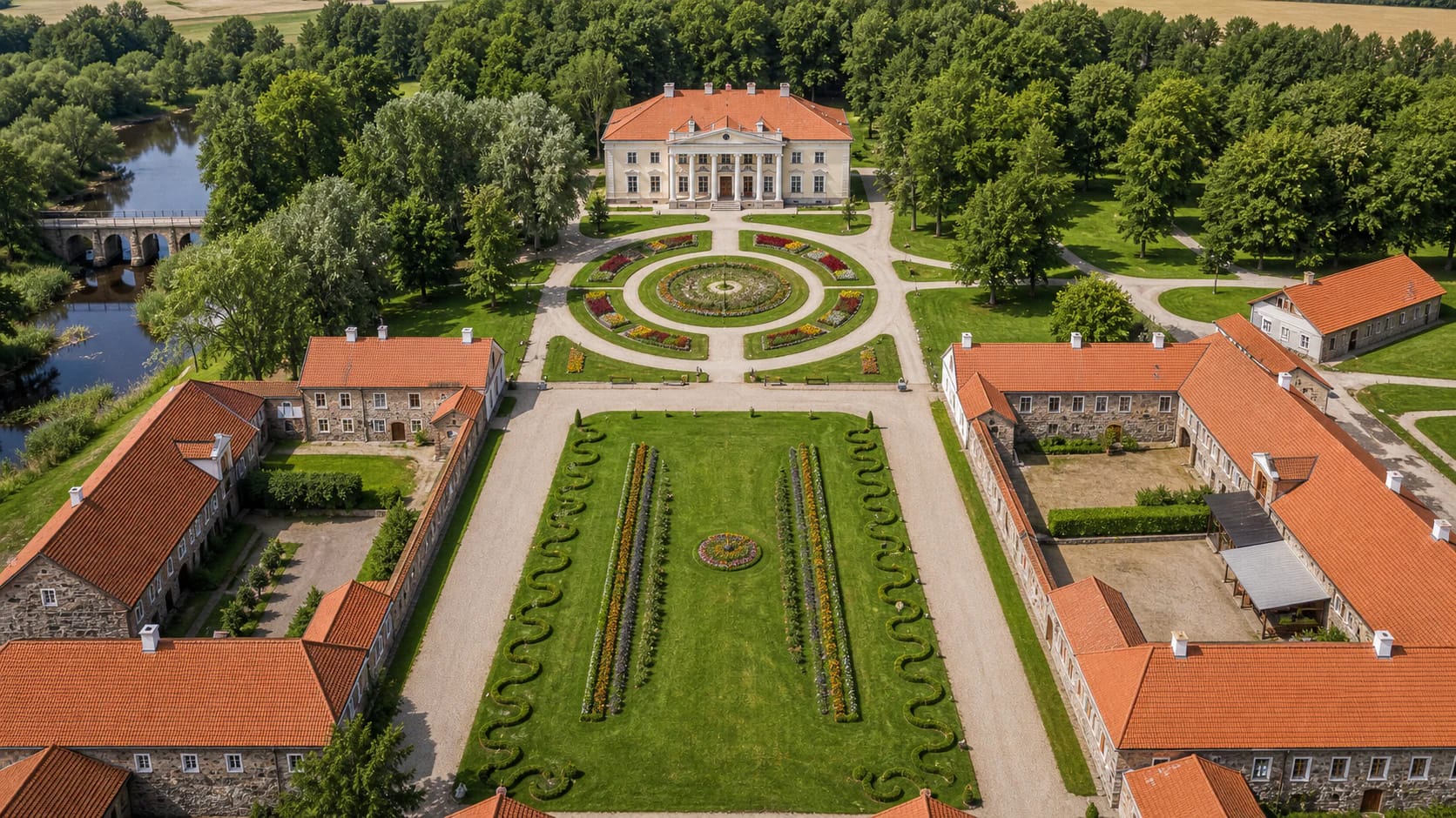 Pakruojis Manor palace, red-roofed farm buildings, park, and the Kruoja River from above