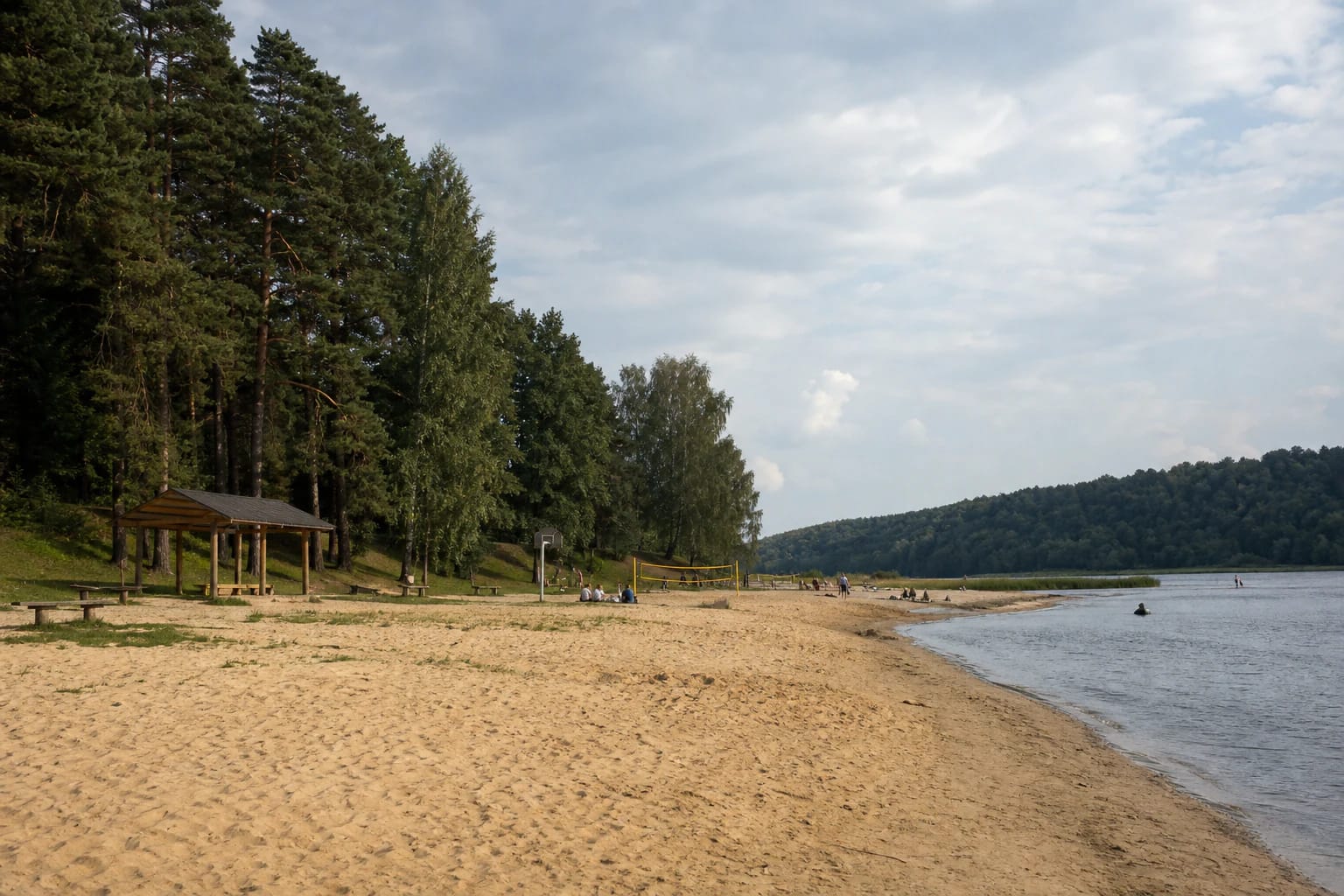 Sandy Panemunė Beach on the Nemunas with a shelter, volleyball court, and pine woodland