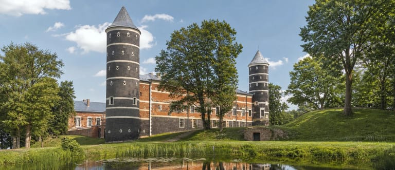 Panemunės pilies bokštai, raudonų plytų korpusai ir parkas prie tvenkinio