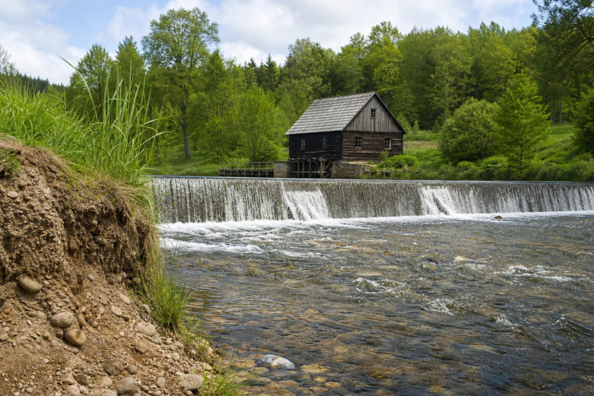 Papartynė watermill and dam in the valley below a geological outcrop