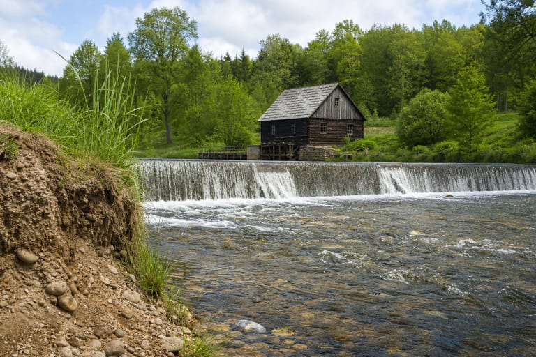 Papartynė watermill and dam in the valley below a geological outcrop
