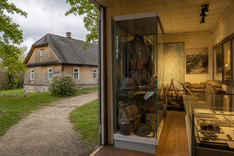The former Turmantas school and a museum display with a First World War uniform, maps and excavated objects