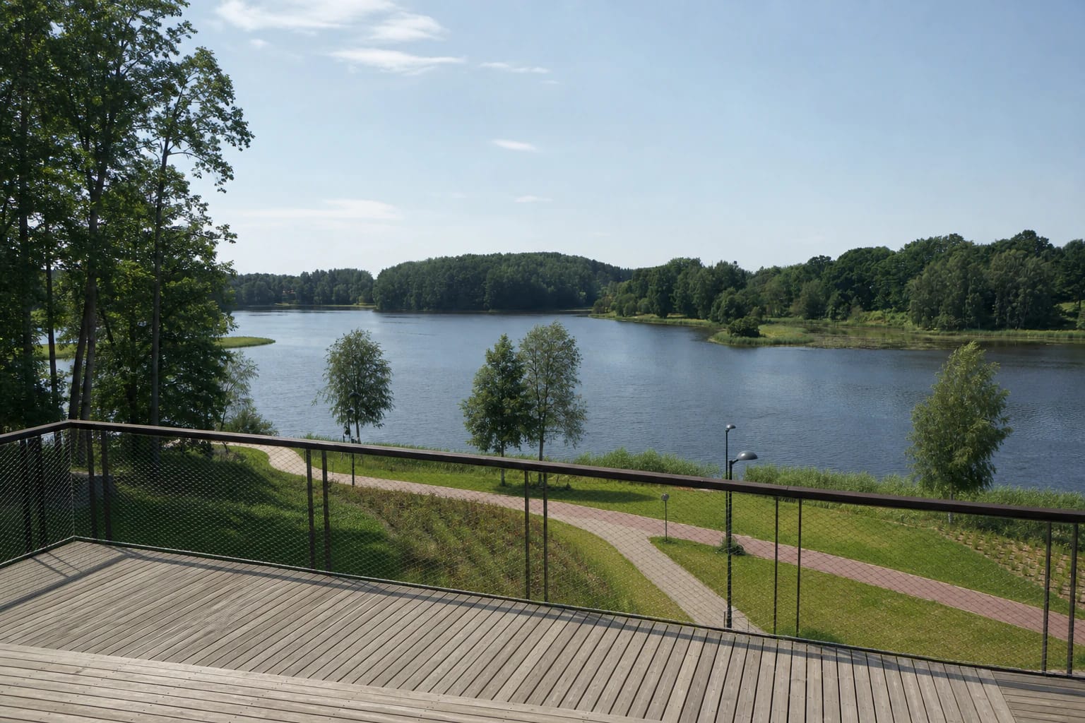 Plungė Sea from a timber viewpoint with a green bank, shoreline path, and wooded islands