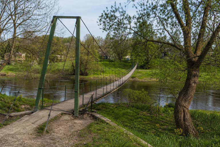 Medinis Priekulės kabantis tiltas per Miniją prie žalių miestelio krantų