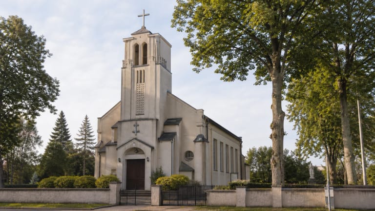 Priekulės Šv. Antano Paduviečio bažnyčia su centriniu bokštu ir šventoriaus liepomis