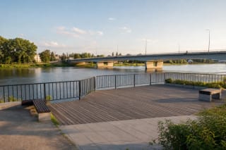Смотровая площадка на берегу Немана в Приенаях с перилами, широкой рекой и мостом Греймаса на заднем плане