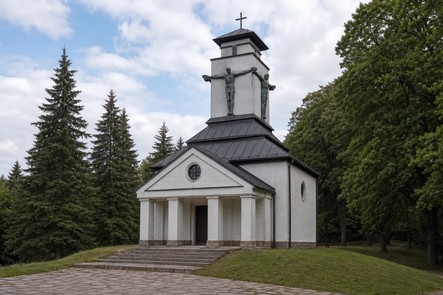 Balta Rainių Kančios koplyčia su laiptuotu tamsiu stogu, aukštu bokštu ir keturiomis varinėmis kankinių figūromis