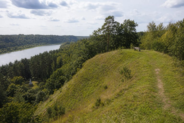 Green Ringovė Hillfort slope above the Nemunas valley with a bench on the summit