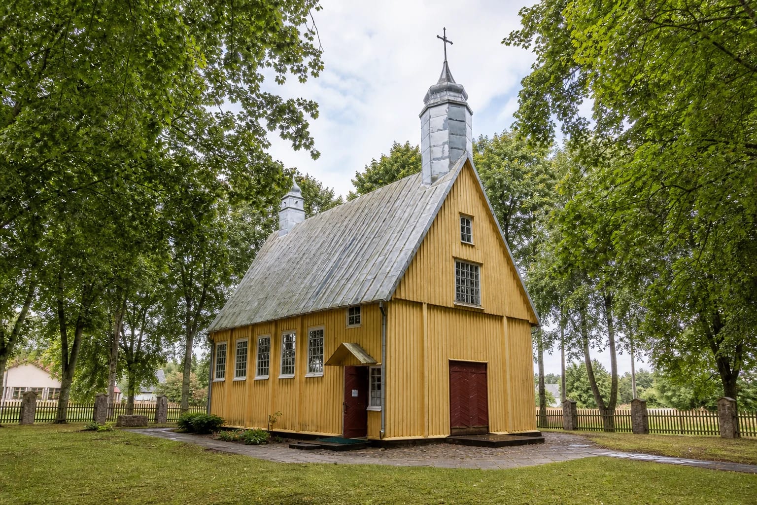 Rubikai wooden Church of St Roch with a grey roof and bell tower
