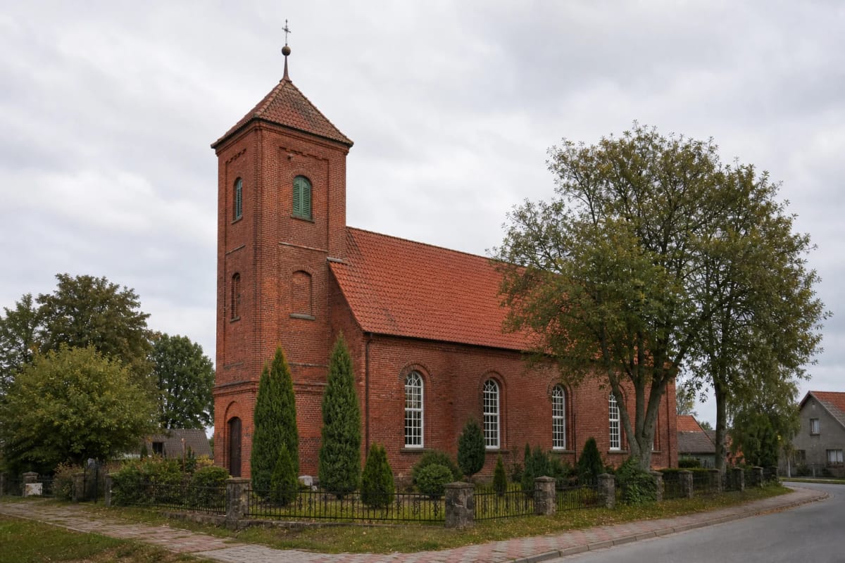 Red-brick Rusnė Evangelical Lutheran Church with a tower in the Pamarys town setting