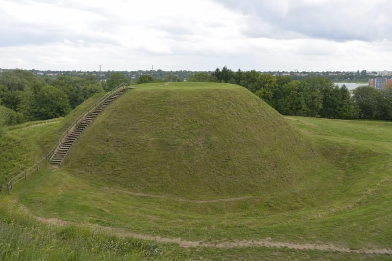 Salduvės piliakalnio žolėta kalva su vakariniais laiptais ir Šiaulių miesto pakraščio panorama