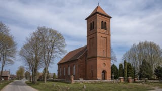 Saugos Evangelical Lutheran Church with a red-brick facade and small towerlet