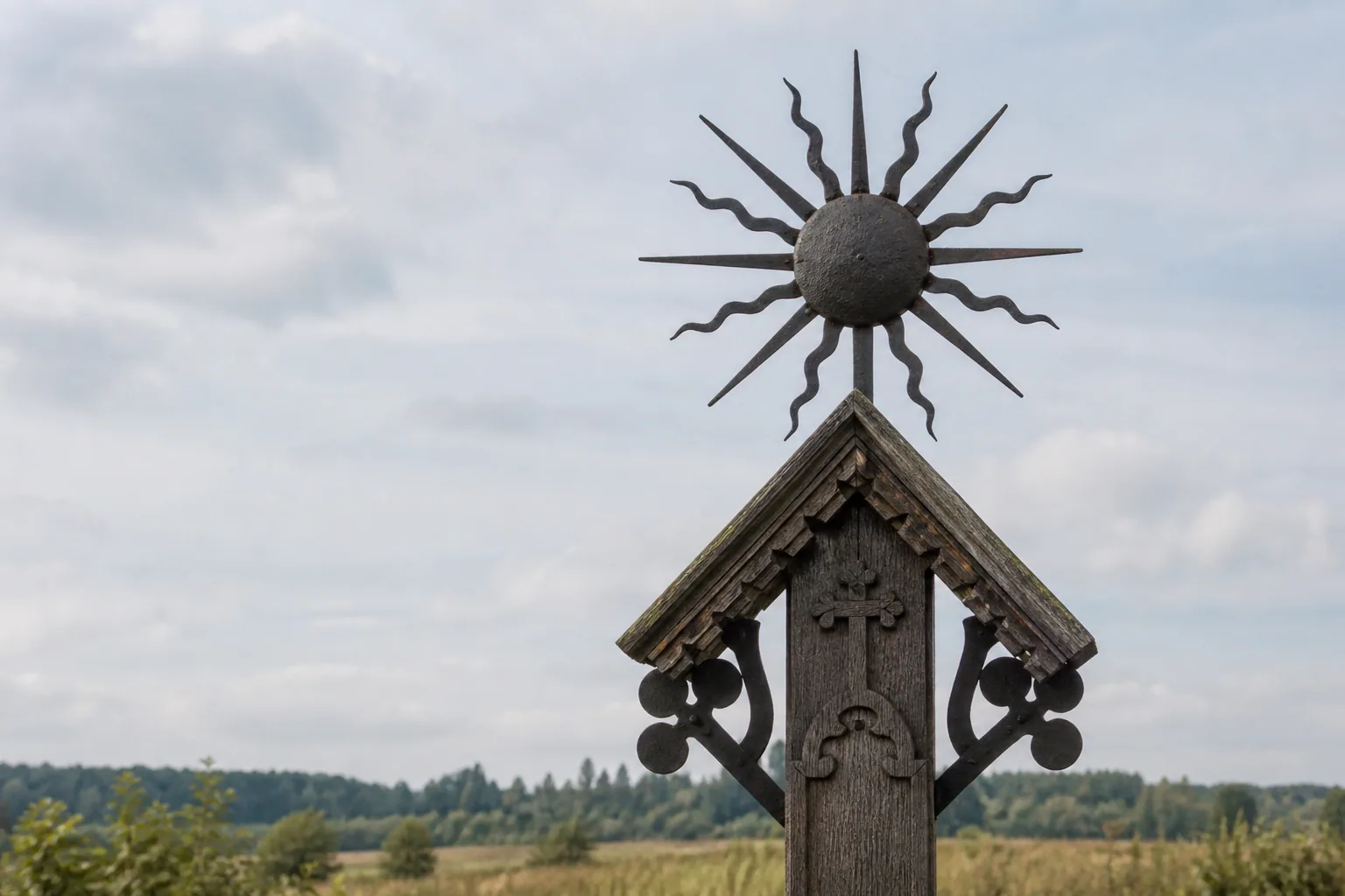 Iron sunburst on a roadside cross in a Lithuanian field.