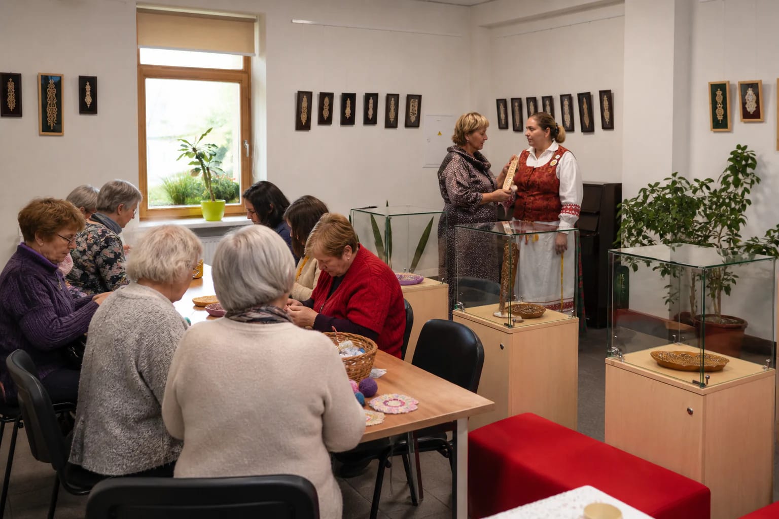 Šeduvos kultūros ir amatų centro parodų salė su stiklo vitrinomis ir tradiciniais medžio raižiniais