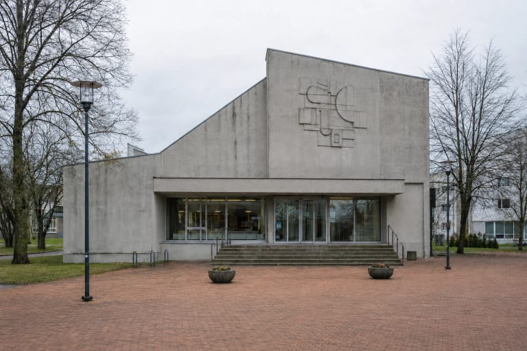 Šiaulių dailės galerijos pilko betono fasadas, reljefinis ženklas ir įstiklintas įėjimas Vilniaus gatvėje