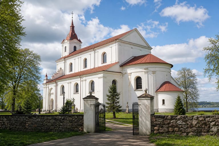 Simno bažnyčia su baltu mūru, raudonu stogu ir šventoriaus vartais prie ežero