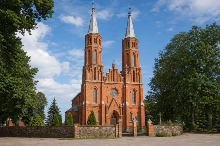 Skirsnemunės Šv. Jurgio raudonų plytų bažnyčia su dviem sidabriniais bokštais ir šventoriaus siena