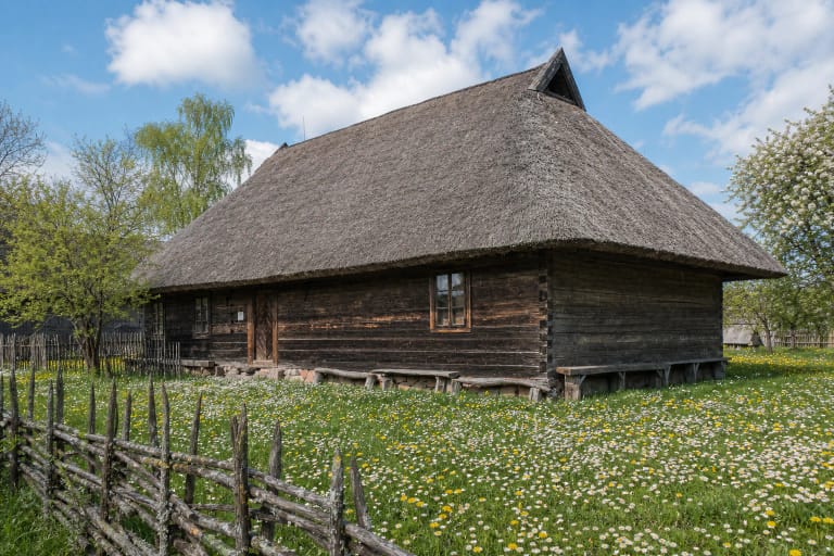 Stasio Girėno gimtinės muziejaus atstatyta medinė žemaitiška troba šiaudiniu stogu už žiogrių tvoros Vytogaloje