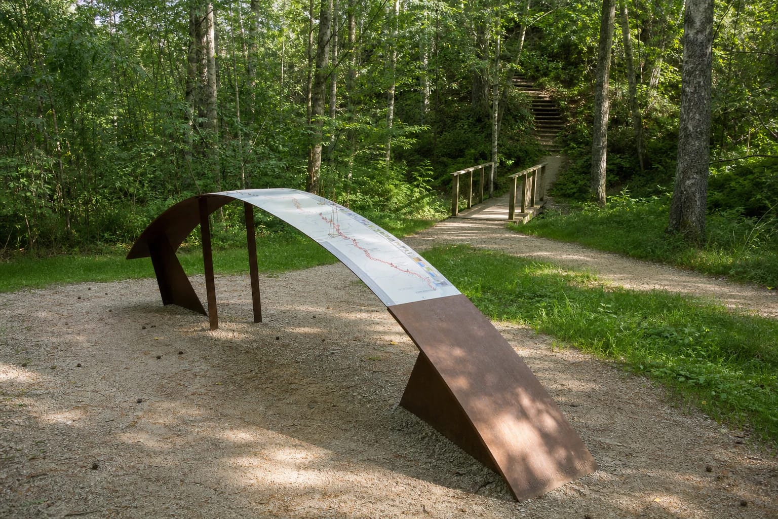 Arc-shaped interpretation display, timber footbridge, and woodland steps on Storiai Nature Trail