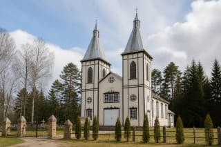 Švedriškės Šv. Jono Krikštytojo bažnyčia su dviem smailiais bokštais tarp miško medžių