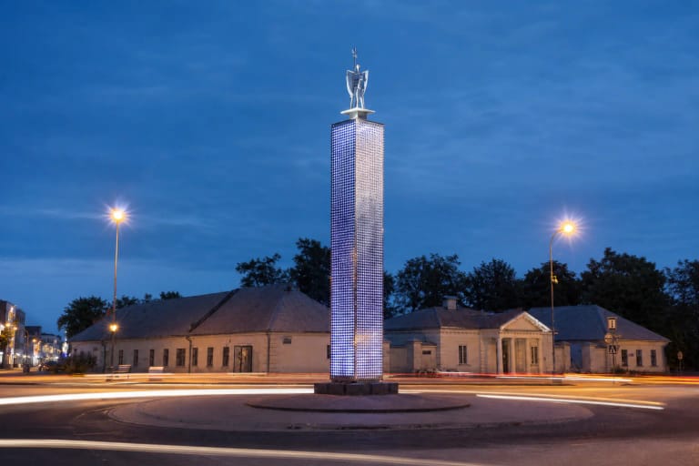 Ažūrinis nerūdijančio plieno Šviesos bokštas su miesto sergėtoju Jonu Jonavos žiede mėlynąją valandą