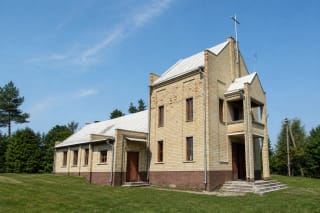 Tauragnai Church of St George in pale brick, with one entrance-tower volume and a metal cross