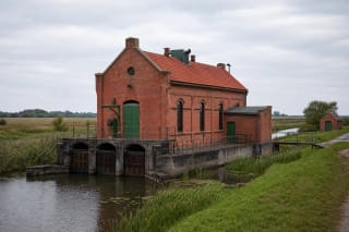 Uostadvaris Water-Lifting Station red-brick building beside a polder canal in the Nemunas Delta