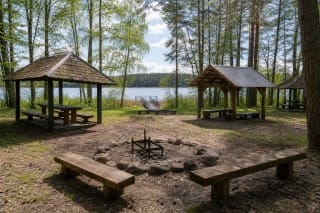 Vaišniūnų stovyklavietės atviros medinės pavėsinės, laužavietė ir turėklais aptvertas lieptas į Dringio ežerą