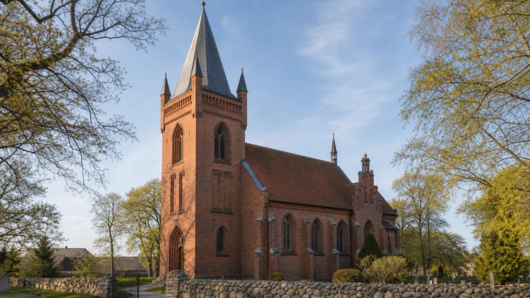 Vanagų evangelikų liuteronų bažnyčia raudonų plytų fasadu ir aukštu bokštu