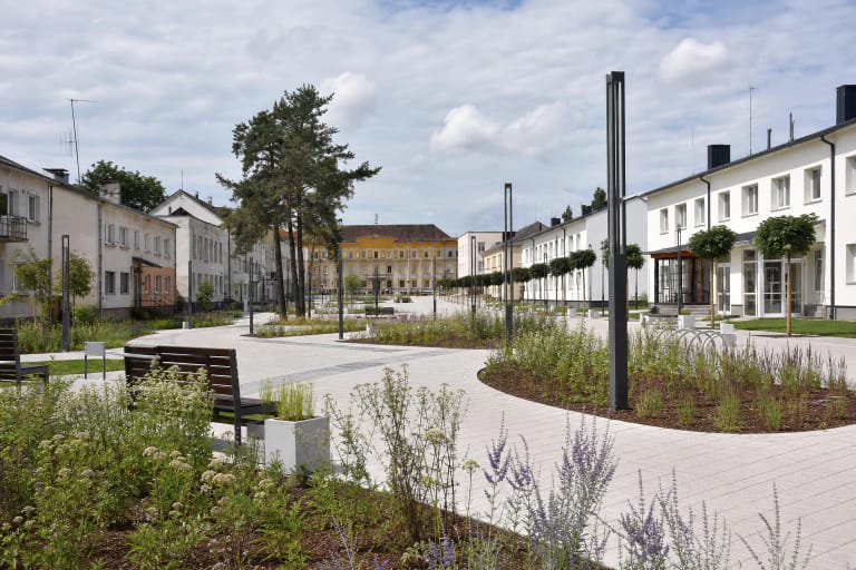 Varėnos pėsčiųjų alėjos šviesūs takai, gėlynai ir tamsūs šviestuvai miesto centre