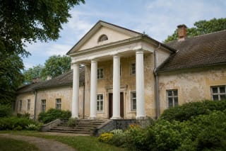 Classicist Vilkaviškis Manor palace with white columns and an old park