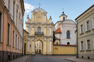 Ornate Baroque gate of the Vilnius Basilian Monastery and the courtyard of Holy Trinity Church
