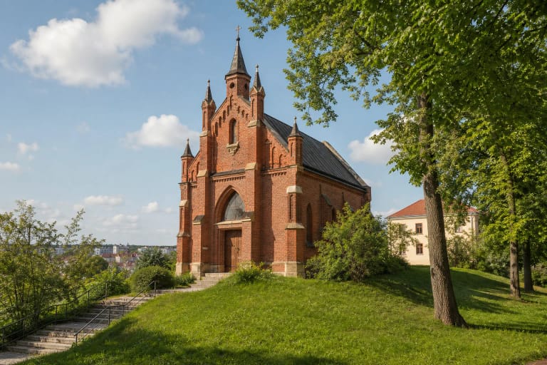 Nedidelė raudonų plytų neogotikinė Dievo Apvaizdos bažnyčia ant žalios Vilkpėdės kalvos