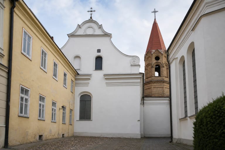 White Baroque Evangelical Lutheran Church in Vilnius and its brick belfry inside the Vokiečių Street courtyard