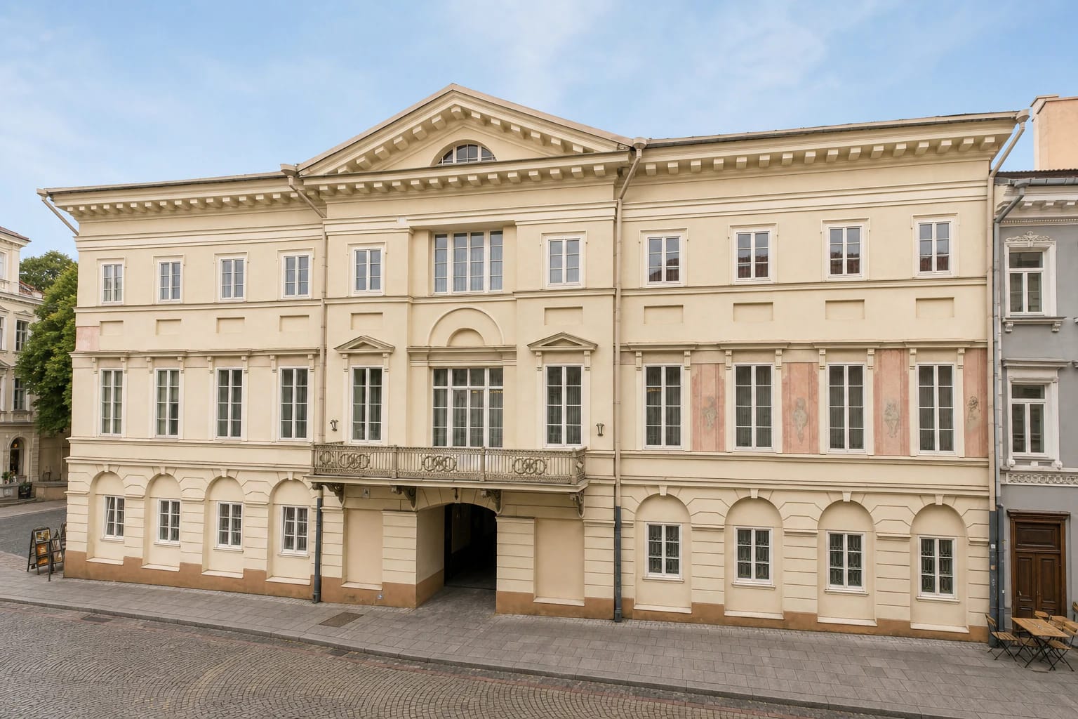 Pale late-Classical façade of Vilnius Picture Gallery on Didžioji Street, with a central pediment and balcony